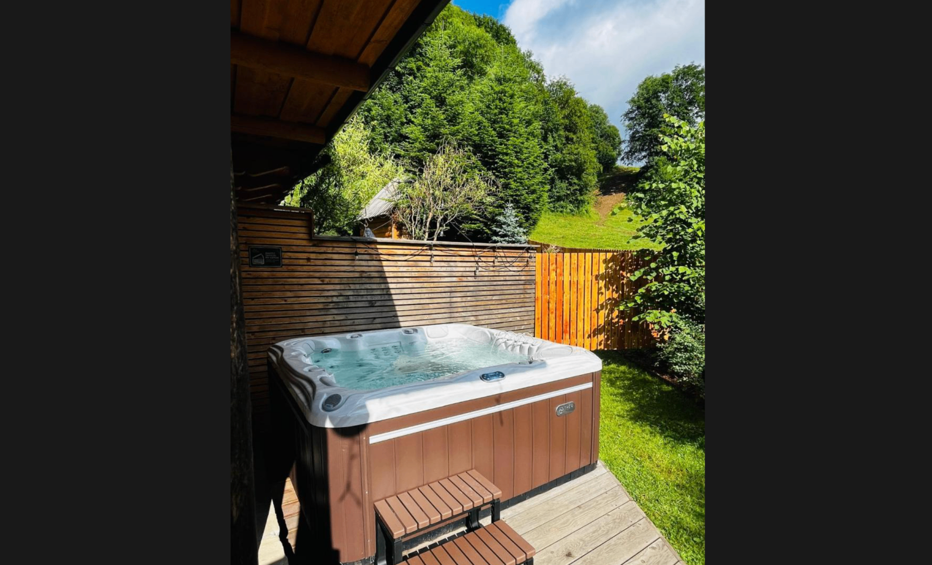 Jacuzzi pod zadaszeniem z widokiem na ogród